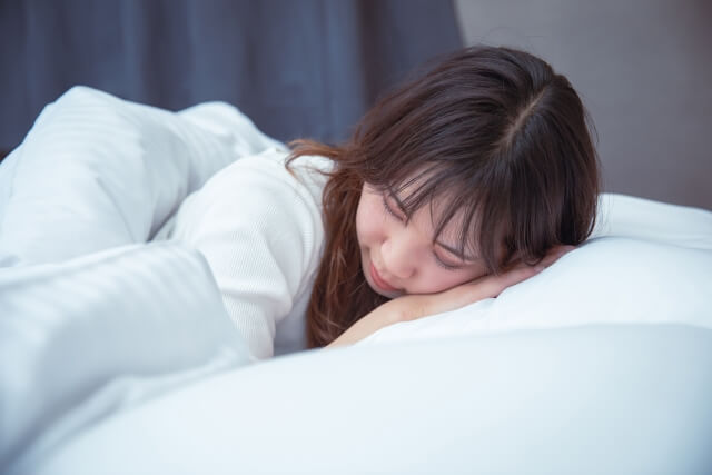 うつぶせ寝をしている女性の画像