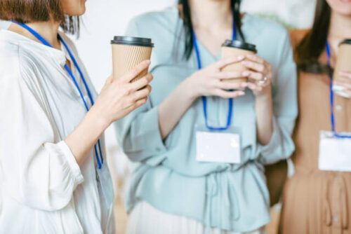コーヒーを持ちながら話をしている３人の女性の画像